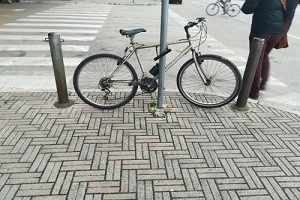 U字ロックで柱に繋がれた自転車の写真