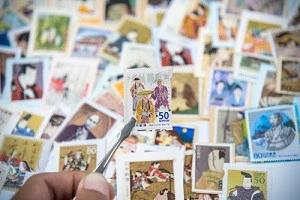 コレクターが切手をピンセットで持っている写真