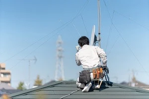 事業者がアンテナを屋根に設置している写真