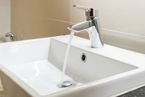 水を出している洗面所の蛇口の写真