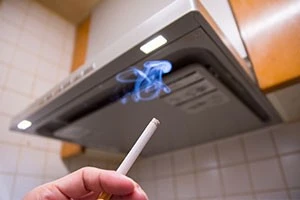 キッチンのダクト下でタバコを吸っている写真