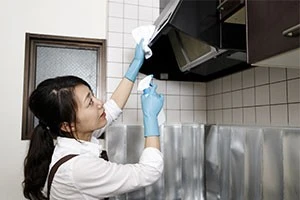 レンジフードを掃除している女性の写真