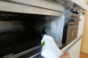 煙が出ている魚焼きグリルを修理する写真